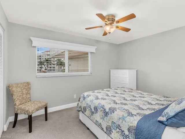 Bedroom with ceiling fan and light colored carpet