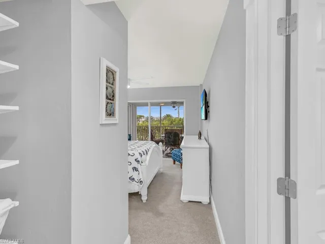Hallway featuring light carpet