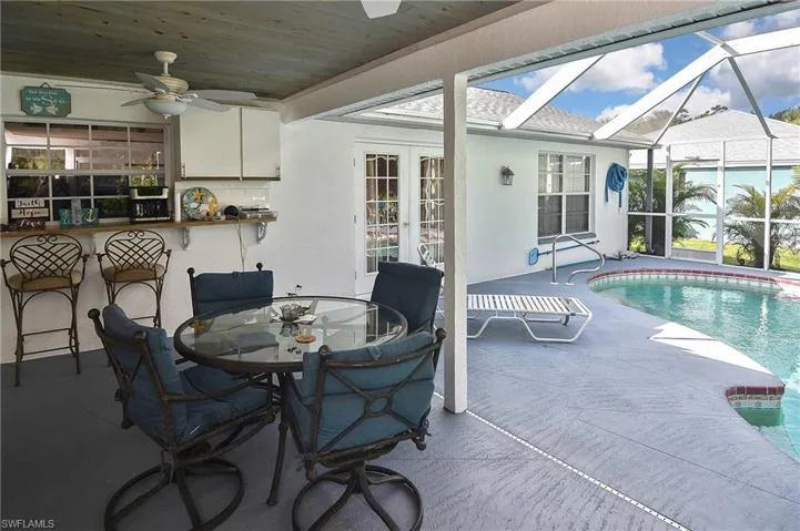View of swimming pool featuring a patio, a lanai, and ceiling fan