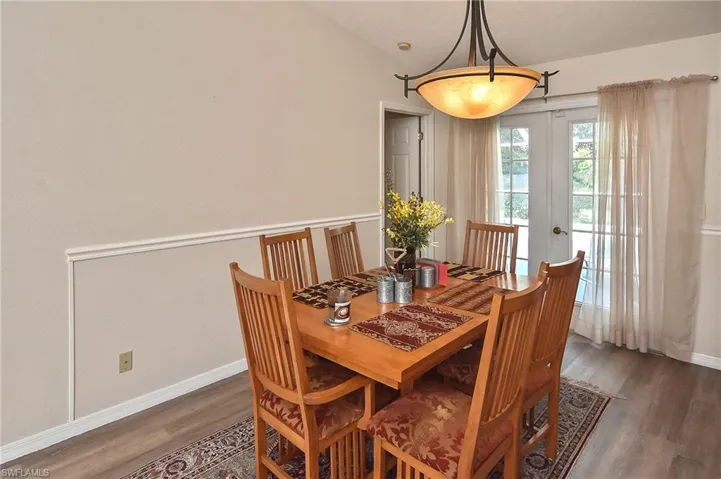 Dining space featuring dark hardwood / wood-style floors, french doors, and vaulted ceiling