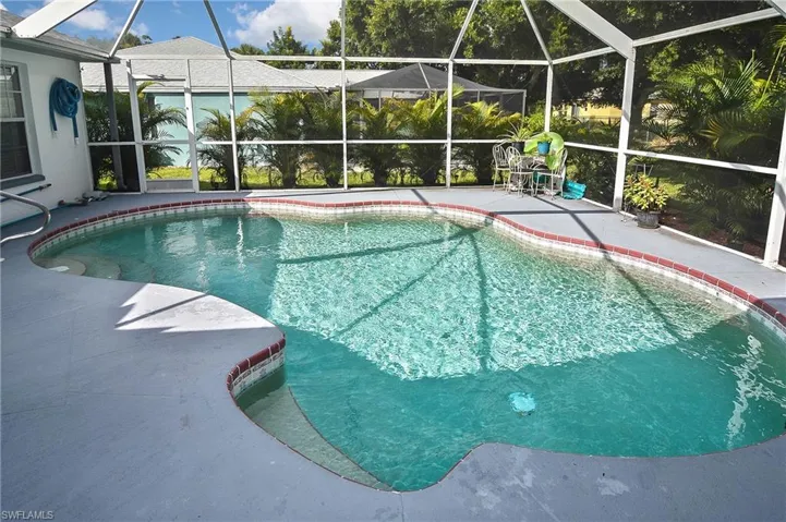 View of pool featuring a patio and glass enclosure