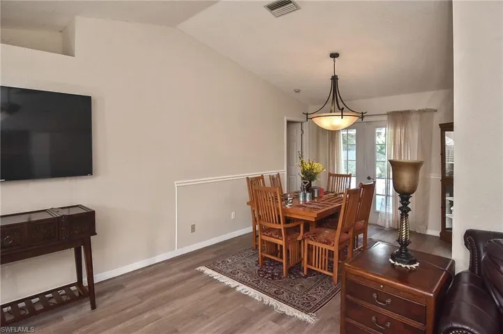 Dining space with dark wood-type flooring and lofted ceiling