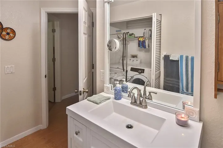 Bathroom with vanity, washer / dryer, and hardwood / wood-style floors