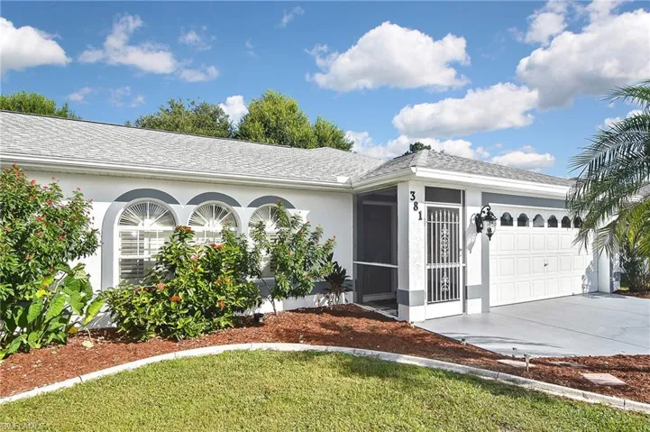 Ranch-style house with a garage and a front lawn