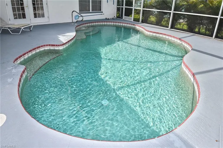 View of pool with a patio area and a lanai