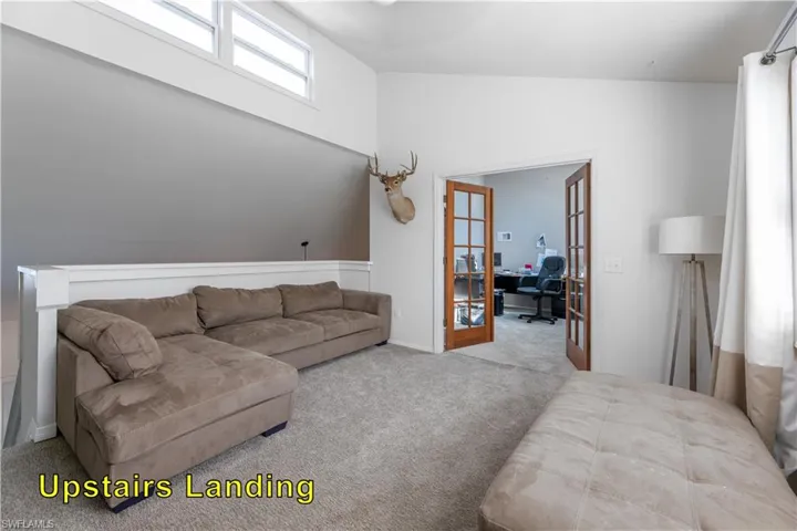 Carpeted living area featuring french doors