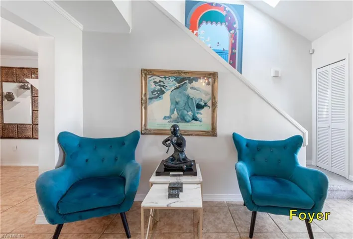 Living area featuring ornamental molding, tile patterned flooring, and baseboards
