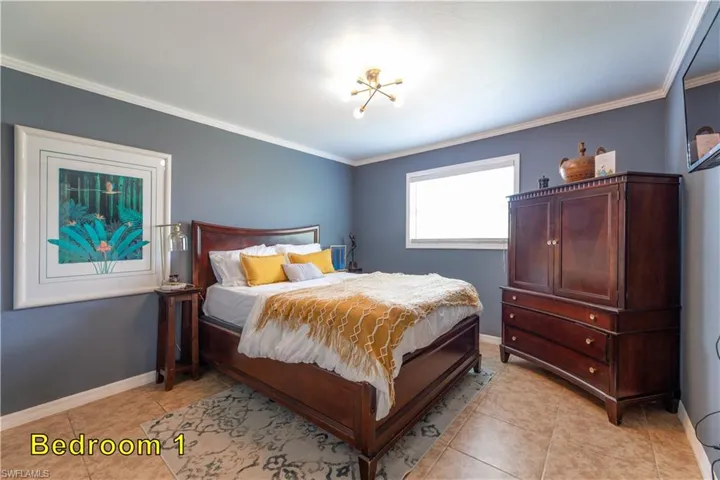 Bedroom with baseboards, ornamental molding, and light tile patterned flooring