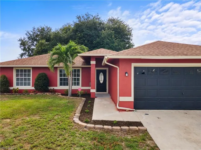 Single story home featuring a front lawn, a garage, concrete driveway, stucco siding, and a shingled roof