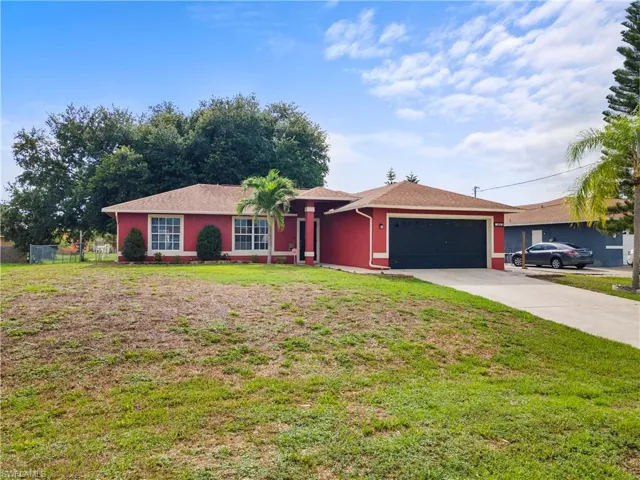 Single story home with a garage, driveway, and stucco siding