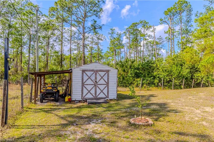 View of outbuilding featuring a lawn