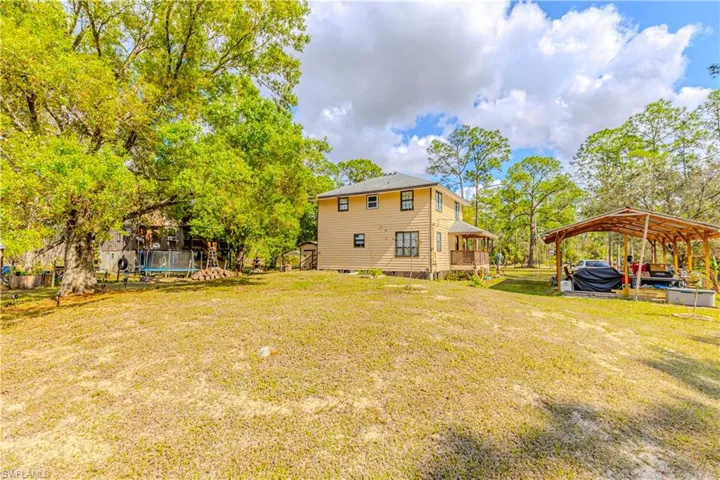 View of yard featuring a carport and a storage shed