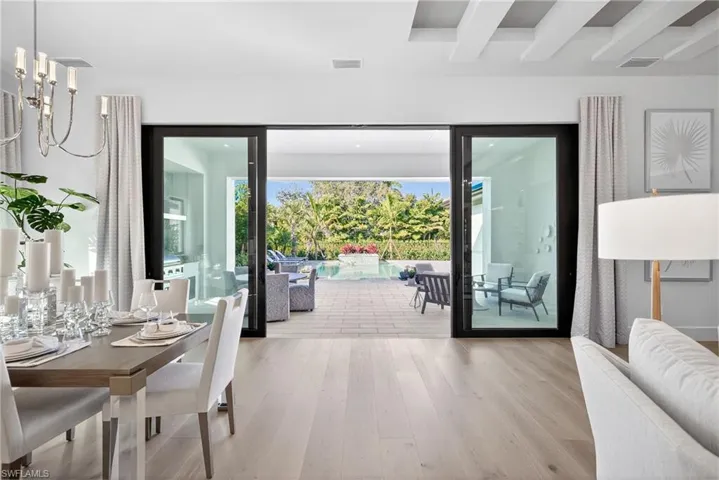 Dramatic view to the outdoor space from kitchen/dining area shows off the  gorgeous wood floors