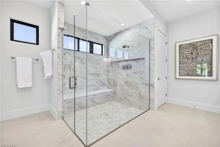 Spacious master suites bathroom with large marble tiled shower, the transom windows give plenty of  natural lighting