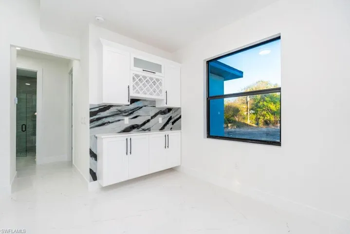Bedroom featuring baseboards and light marble finish floors