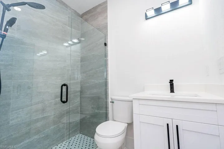 Full bathroom featuring a stall shower and vanity