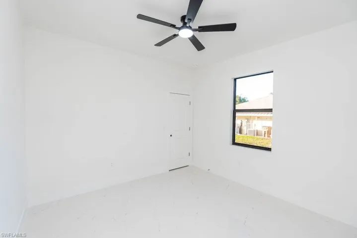 Spare room with a ceiling fan and marble finish floors