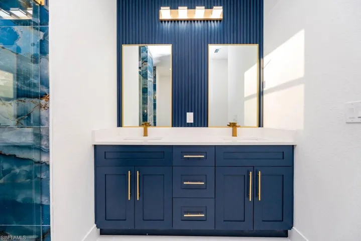 Bathroom featuring double vanity and baseboards