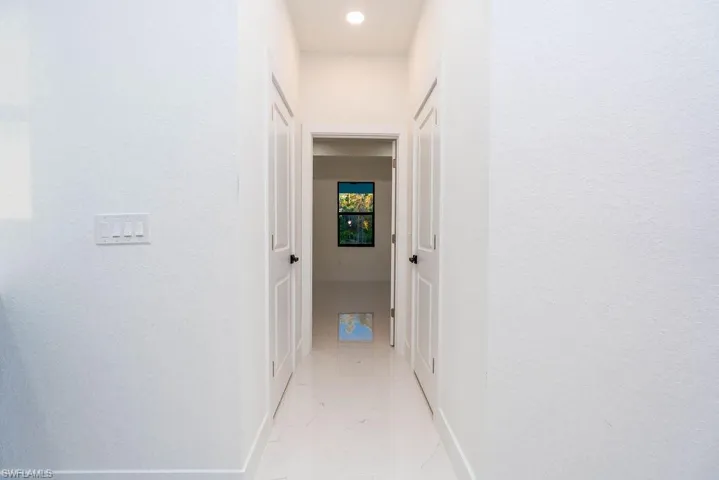 Hall with baseboards and light marble finish floors