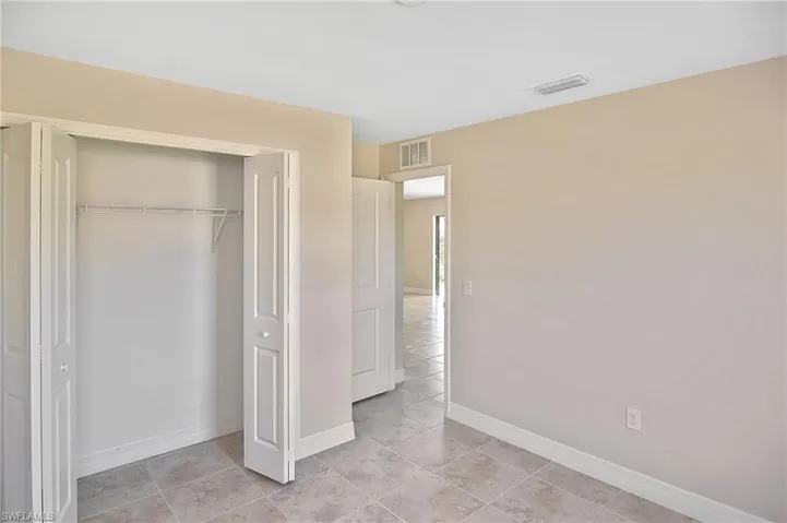 Unfurnished bedroom with light tile patterned floors and a closet