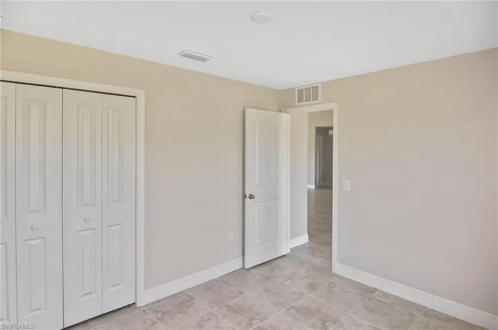 Unfurnished bedroom featuring a closet and light tile patterned floors