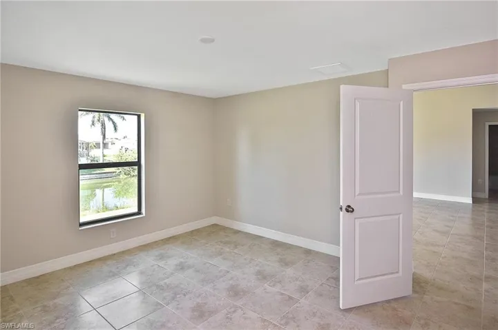 Spare room featuring light tile patterned floors and a water view