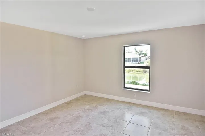 Empty room featuring baseboards and light tile patterned floors