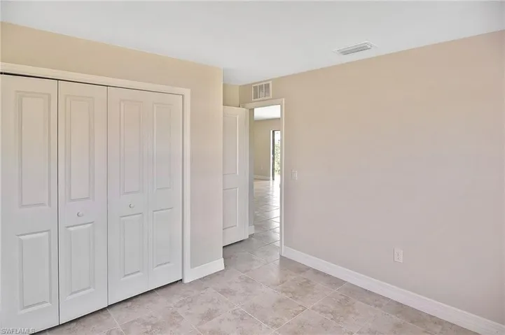 Unfurnished bedroom with a closet and light tile patterned flooring