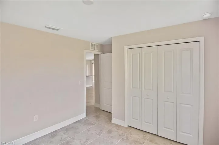 Unfurnished bedroom featuring a closet and light tile patterned flooring