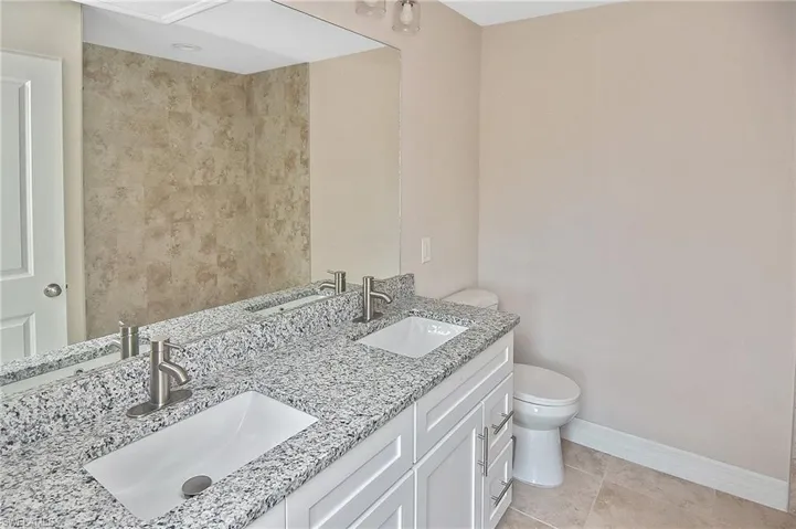 Bathroom featuring double vanity and light tile patterned floors