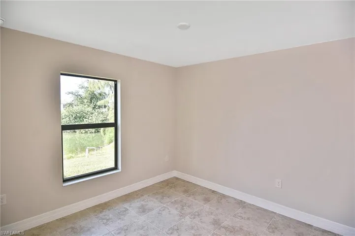 Empty room featuring baseboards and light tile patterned flooring
