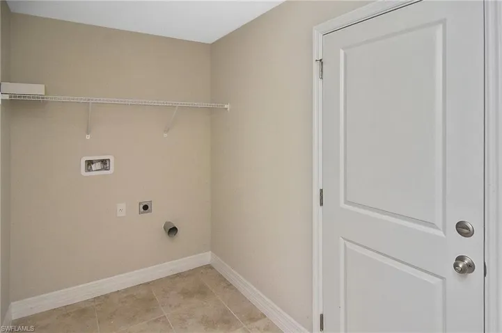 Laundry area featuring hookup for an electric dryer, light tile patterned floors, and hookup for a washing machine