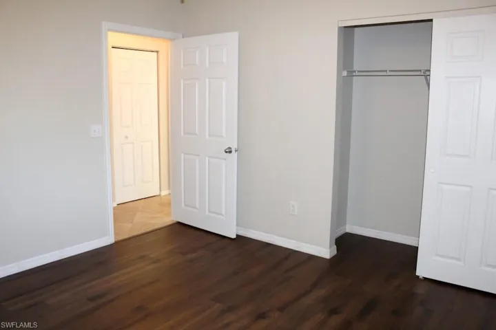 Unfurnished, Front bedroom featuring dark wood-type flooring and a closet