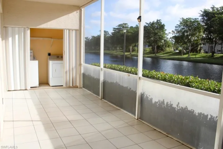 Unfurnished sunroom featuring a water view and independent washer and dryer