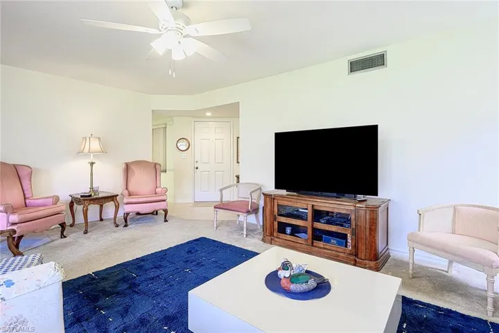Carpeted living room with ceiling fan
