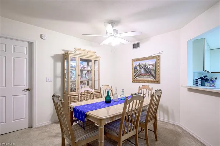 Carpeted dining area with ceiling fan