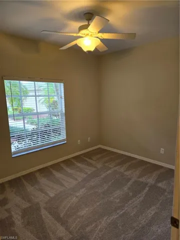 Empty room with ceiling fan and  carpet