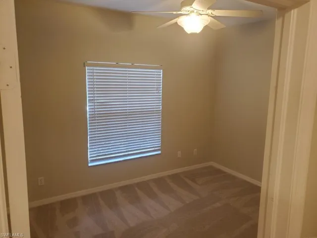 Carpeted spare room featuring ceiling fan