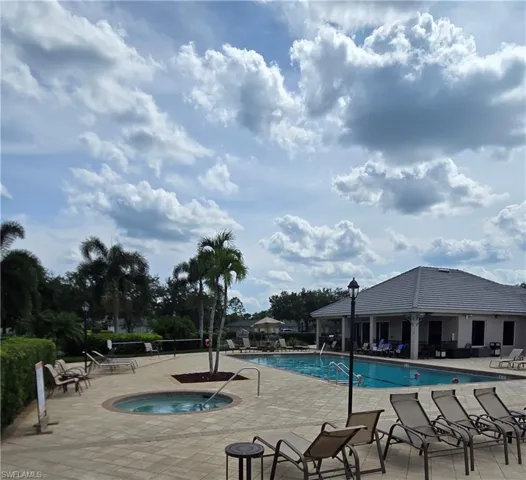 View of swimming pool featuring a community hot tub and a patio area