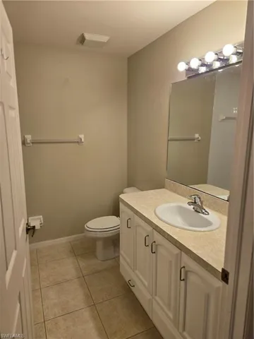 Bathroom featuring toilet, tile patterned floors, and vanity