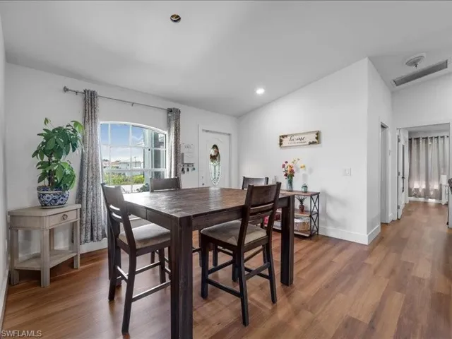 Dining area featuring wood-finish flooring, white walls, and recessed lighting