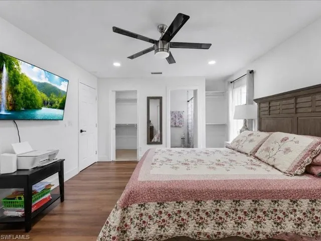 Spacious interior featuring wood-finish flooring, a contemporary ceiling fan, recessed lighting, and white walls
