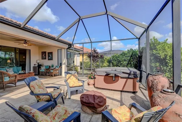 View of patio featuring a hot tub, a lanai, an outdoor hangout area, and ceiling fan