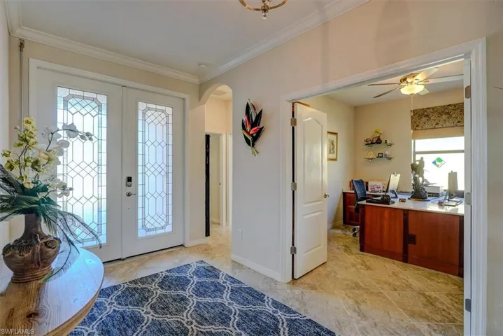 Foyer featuring french doors, ceiling fan, and ornamental molding