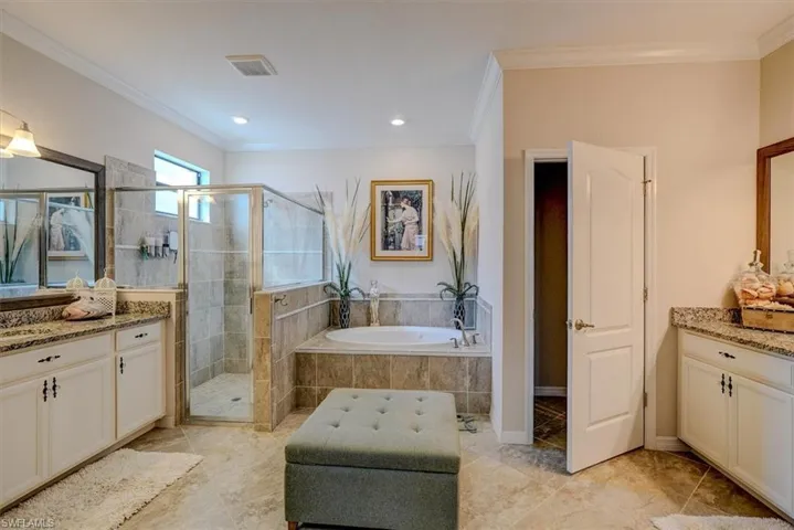 Bathroom with vanity, ornamental molding, and shower with separate bathtub