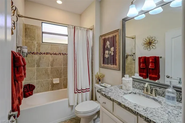 Full bathroom featuring shower / bathtub combination with curtain, vanity, and toilet
