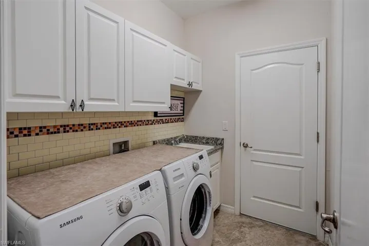 Washroom featuring cabinets, sink, and washer and clothes dryer