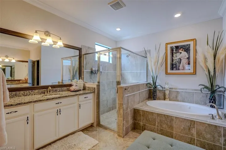 Bathroom featuring tile patterned floors, ornamental molding, separate shower and tub, and vanity