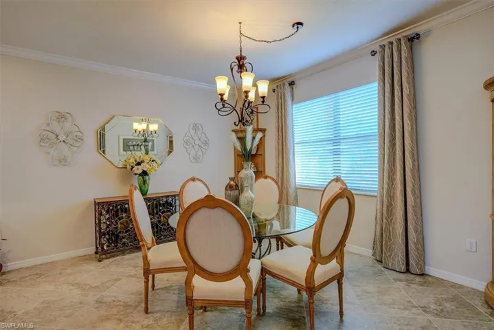 Dining area with crown molding and a chandelier