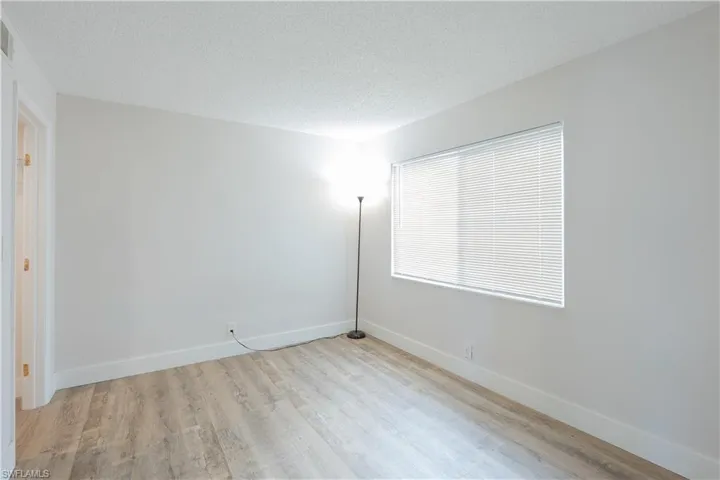 Unfurnished room with a textured ceiling and light wood-style floors